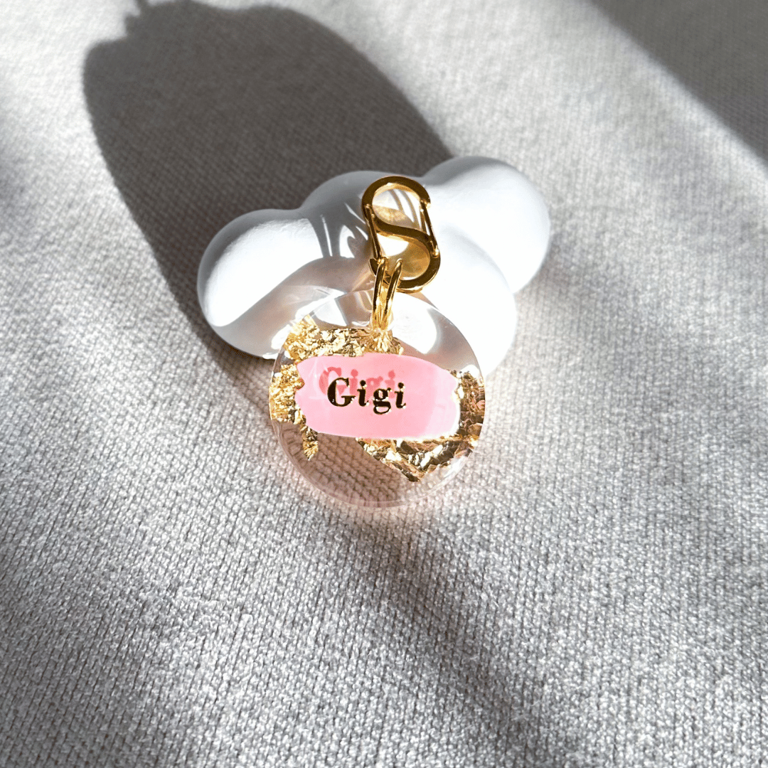 Round pet ID tag with clear resin, baby pink, gold leaf, and gold-plated stainless steel hardware, complimentary gold-plated stainless steel S-clasp.