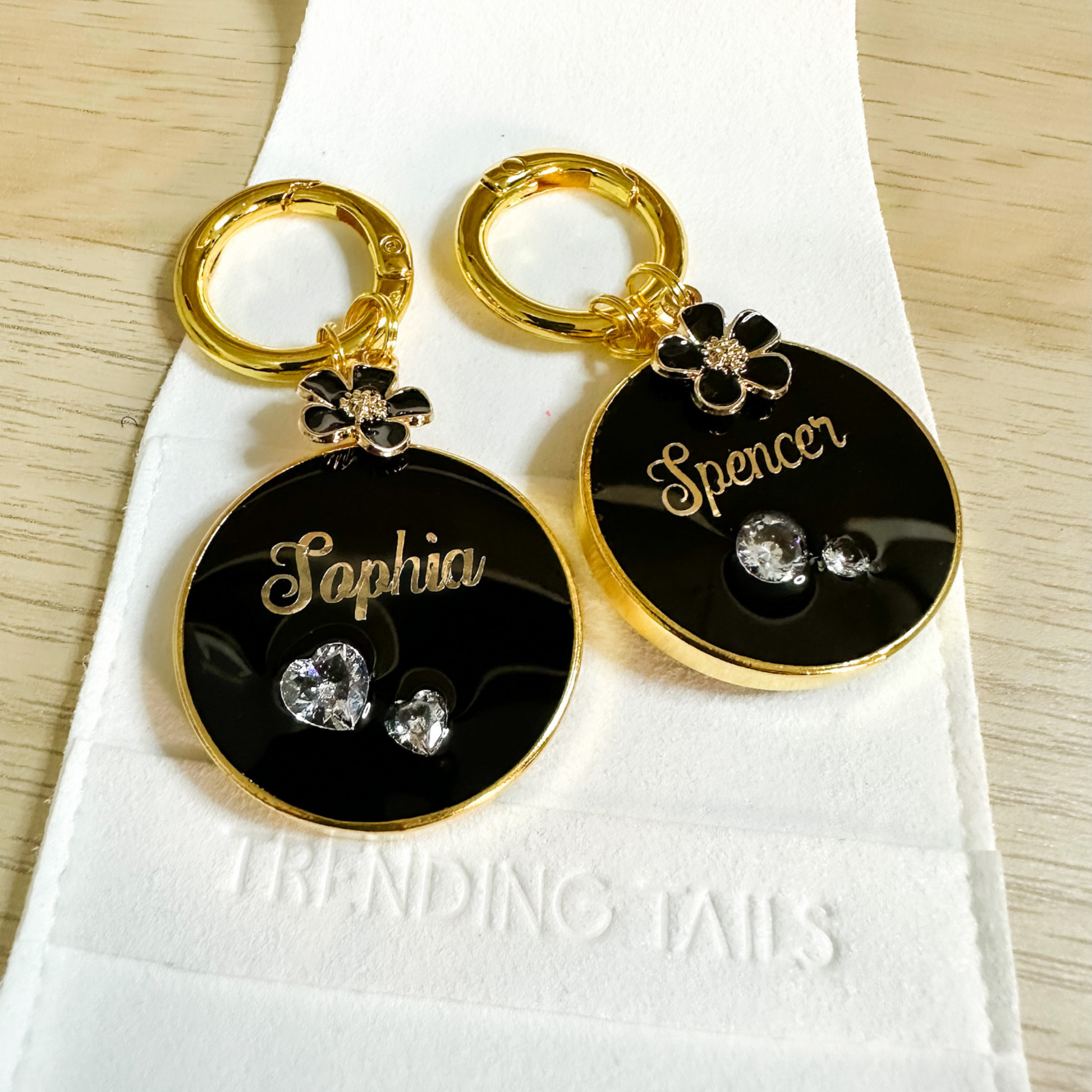 Round black pet ID tag with gold-plated stainless steel hardware and heart-shaped cubic zirconia crystals.