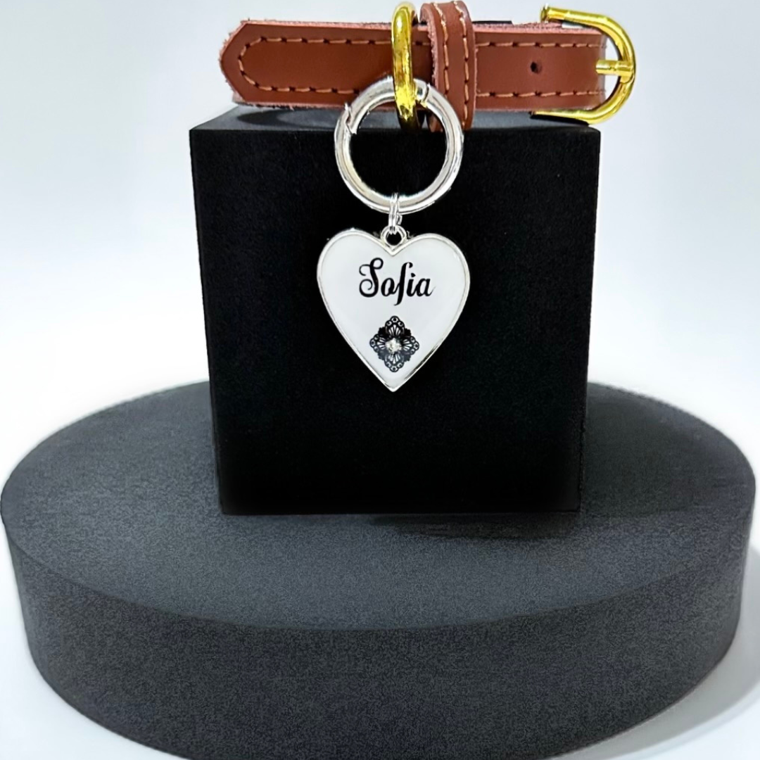 White heart-shaped pet ID tag with stainless steel hardware and Swarovski crystal on black lace pattern.