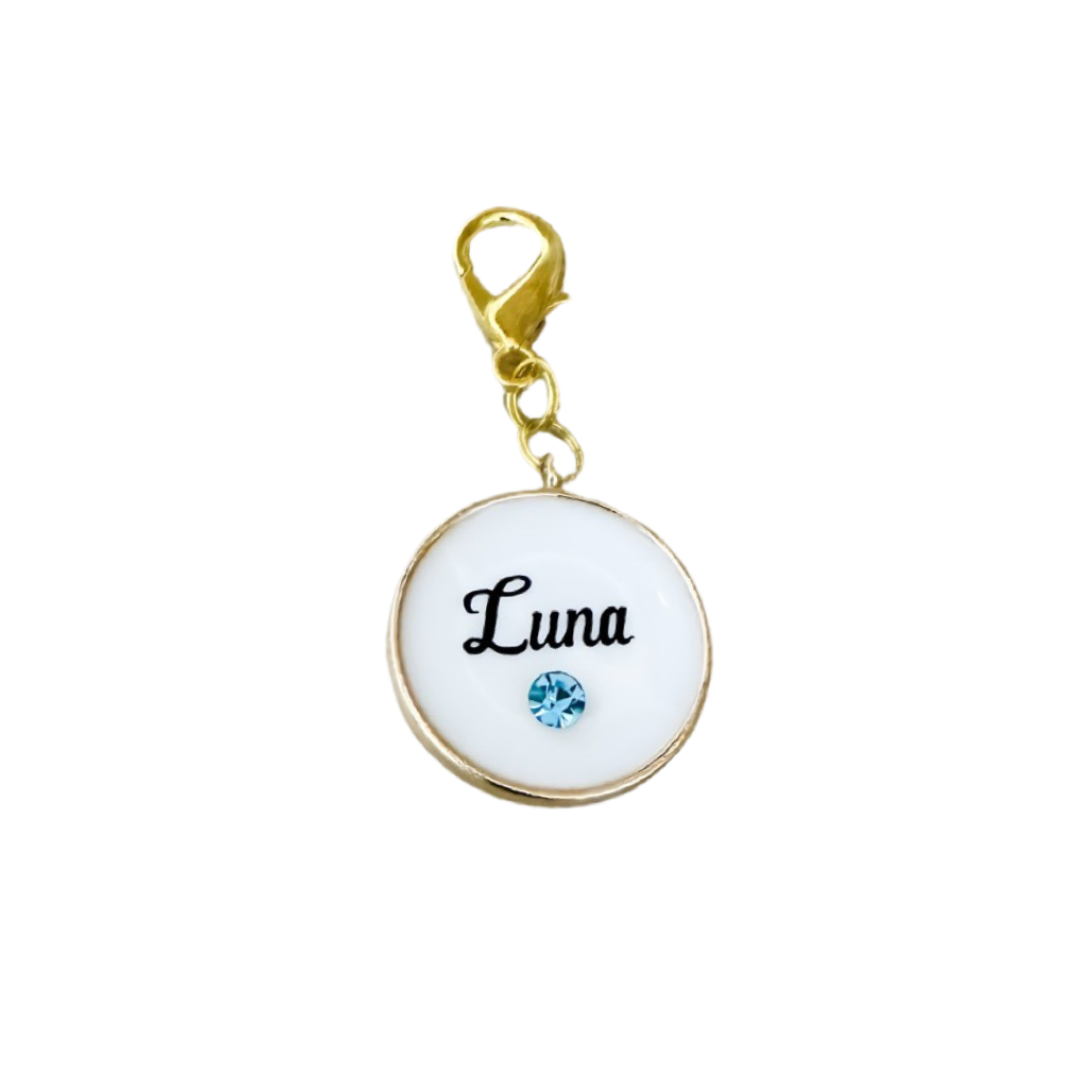 White round pet ID tag with gold-plated stainless steel hardware and blue cubic zirconia crystal.