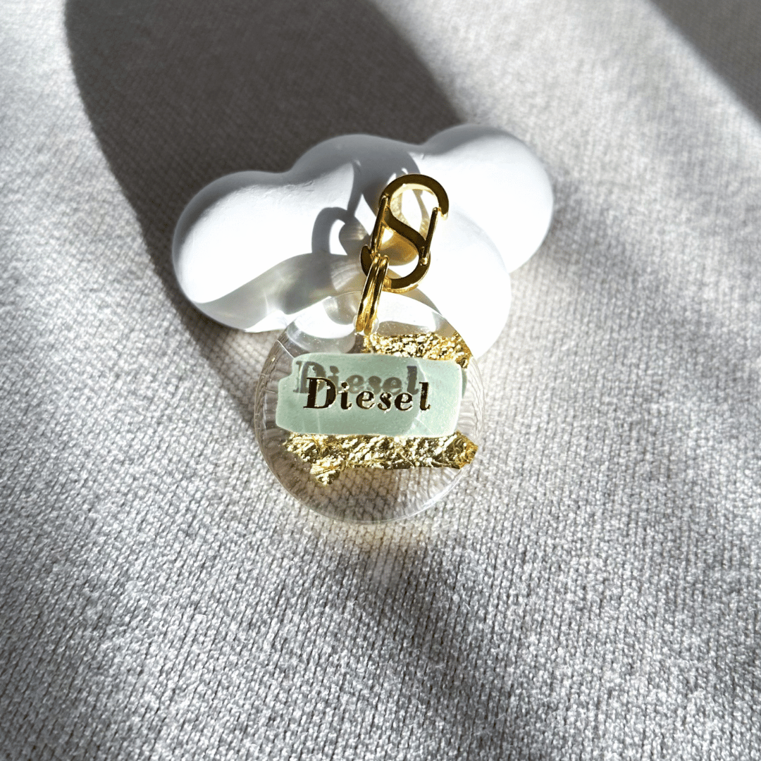 Round pet ID tag with clear resin, khaki green, gold leaf, and gold-plated stainless steel hardware, complimentary gold-plated stainless steel S-clasp.