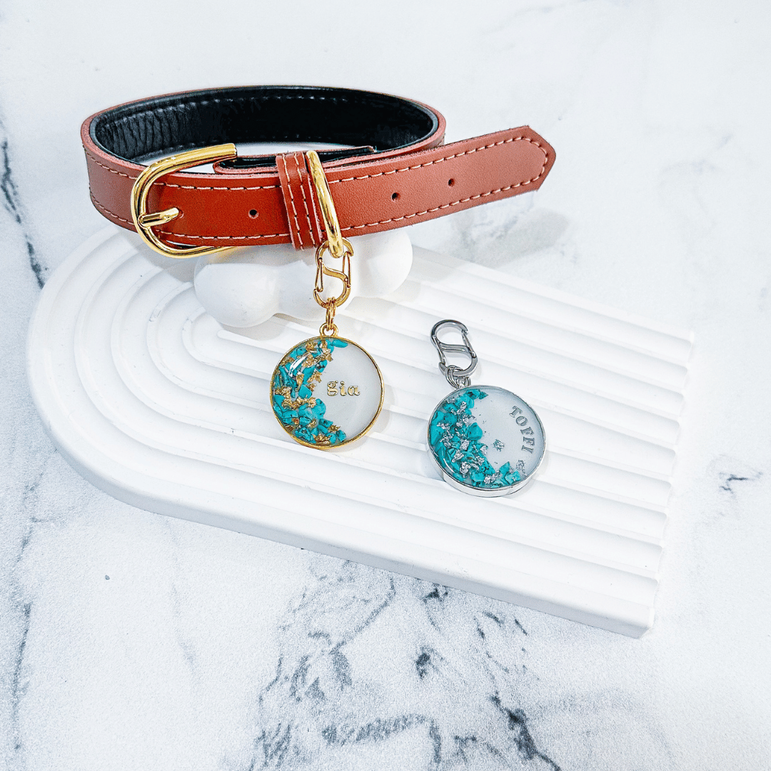 Shimmery white round pet ID tag with gold-plated stainless steel hardware, turquoise blue stones and gold flake, shimmery white round pet ID tag with silver stainless steel hardware, turquoise blue stones and silver foil.