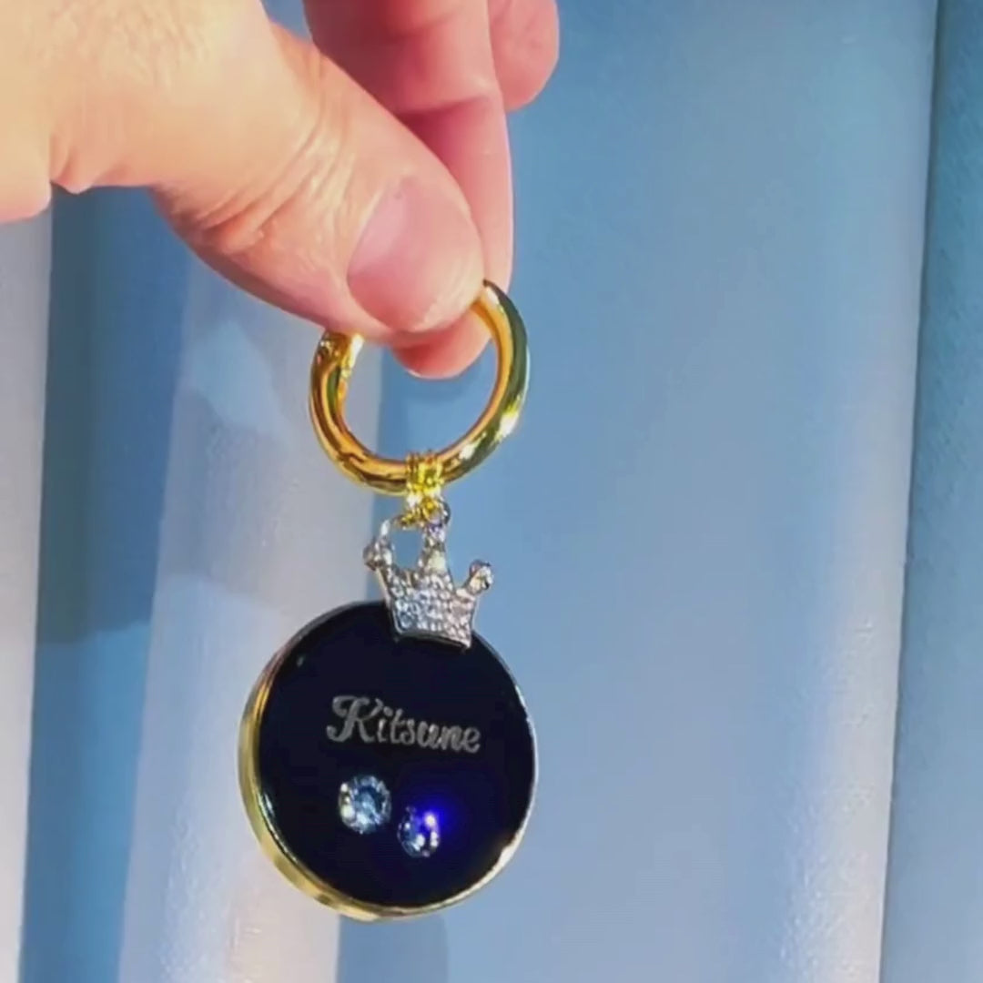 Round black pet ID tag with gold-plated stainless steel hardware and cubic zirconia crystals.